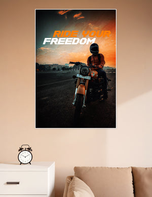 Helmeted motorcycle rider on a Royal Enfield against a dramatic orange sunset sky with bold 'Ride Your Freedom' typography poster
