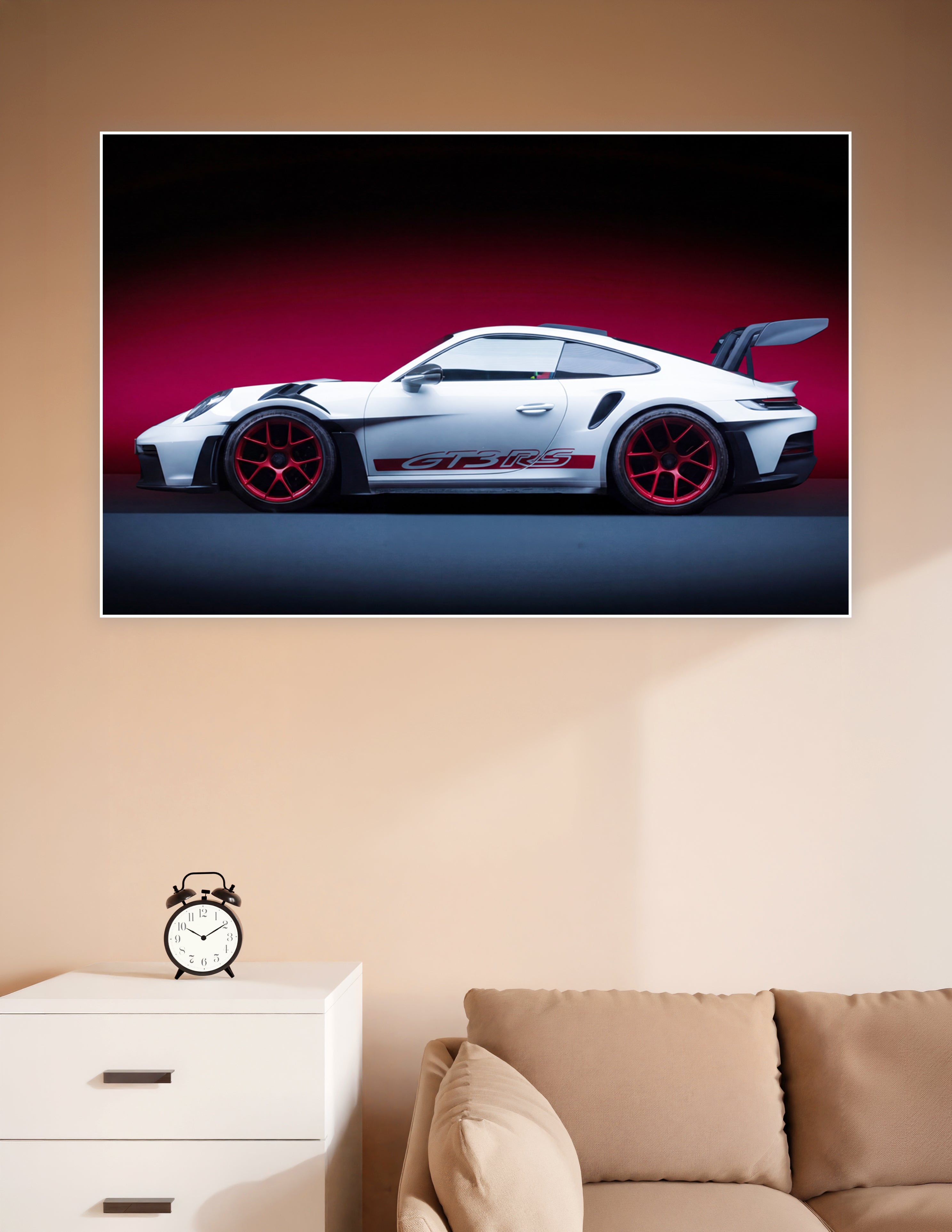 White Porsche 911 GT3 RS with red alloy wheels and rear wing against a crimson studio background, side profile view