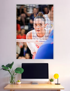 Female volleyball player staring through net at VNL match