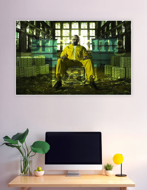 Breaking Bad promotional poster showing Walter White as Heisenberg seated in a yellow hazmat suit surrounded by stacks of cash in a dramatic industrial warehouse with green-tinted lighting