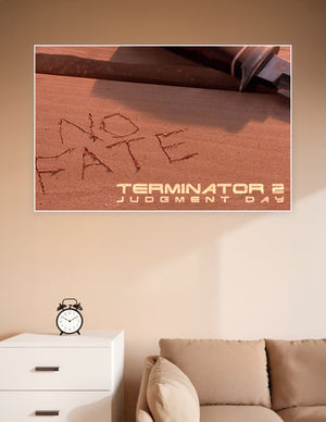 Terminator 2 Judgment Day movie poster showing 'No Fate' carved in sand with a knife in the background, warm amber tones