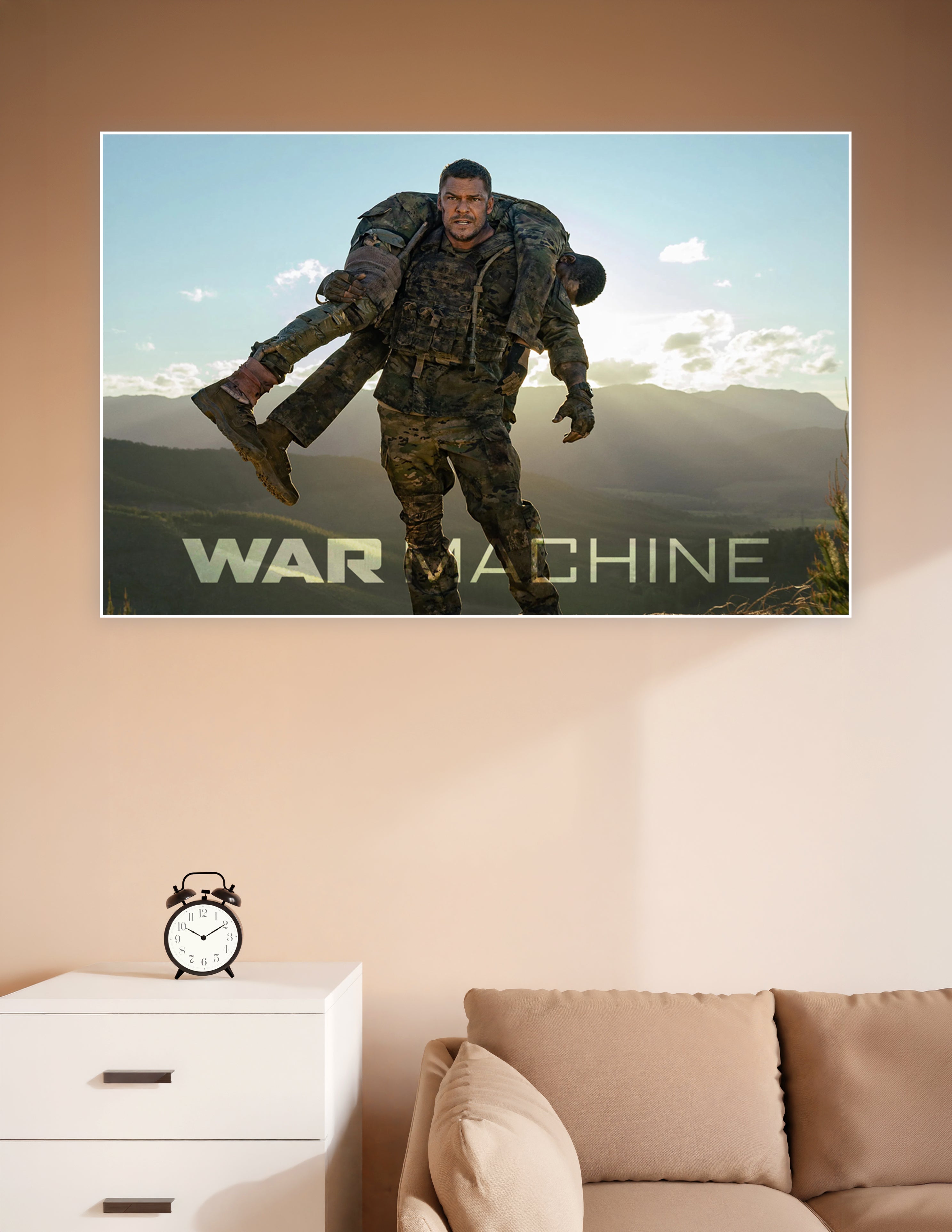 War Machine movie poster showing a soldier in camouflage carrying an injured comrade over his shoulders against a dramatic mountain sunset backdrop