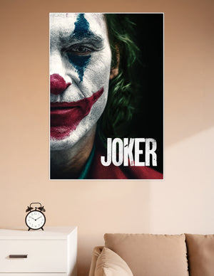 Close-up Joker movie poster showing white face paint, red clown smile, blue tear streak, and green hair on a dark background with bold JOKER title text