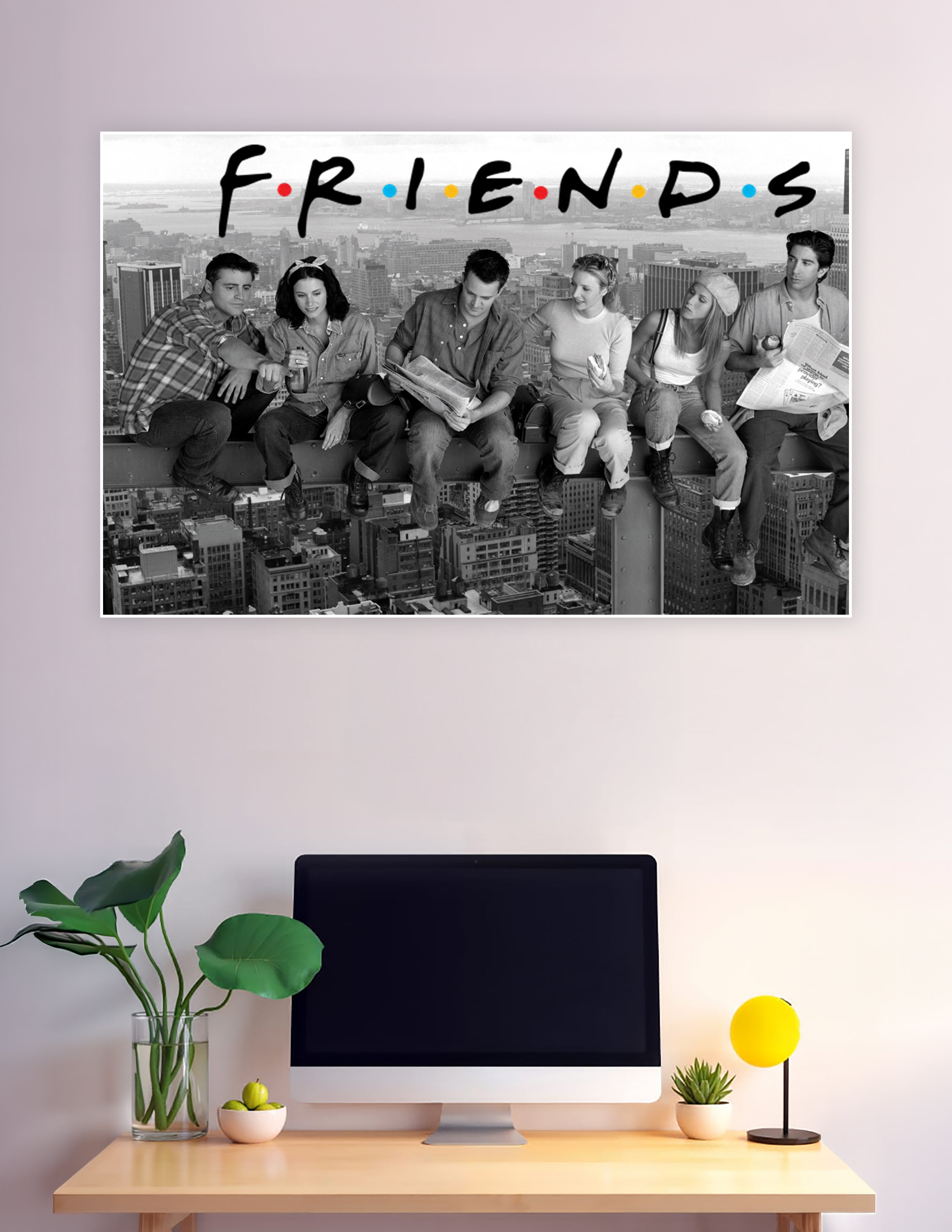 Black and white Friends TV show poster with cast sitting on a skyscraper beam above the New York City skyline with the colorful Friends logo at the top