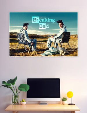 Breaking Bad poster showing Walter White and Jesse Pinkman in hazmat suits sitting in folding chairs in the New Mexico desert with the show's logo above them