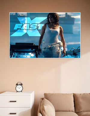 Fast X movie promotional poster featuring a fierce female action hero in a white tank top against a dramatic blue industrial background with the Fast X logo