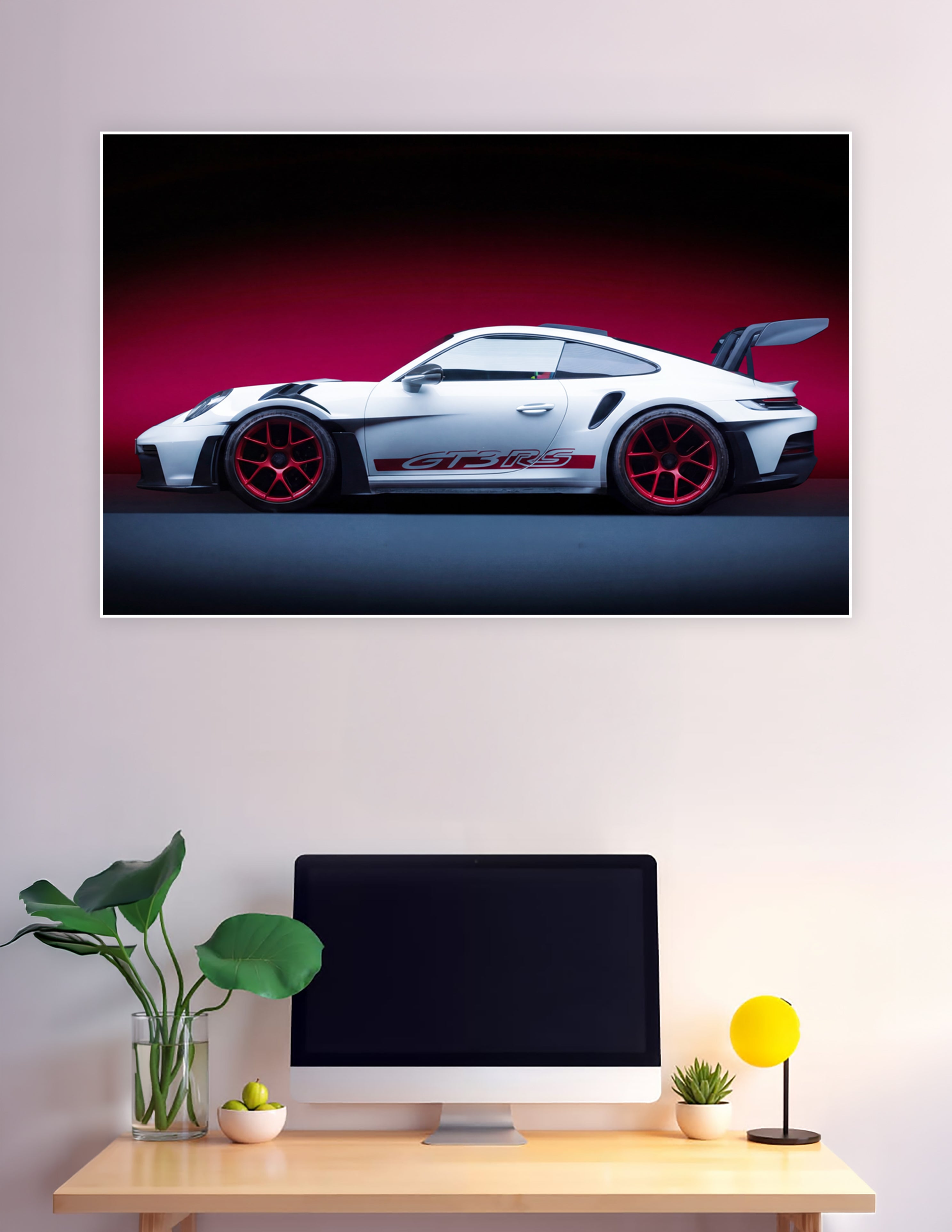 White Porsche 911 GT3 RS with red alloy wheels and rear wing against a crimson studio background, side profile view