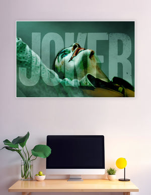 Dramatic close-up Joker movie poster with distressed JOKER typography in teal and dark tones on matte board