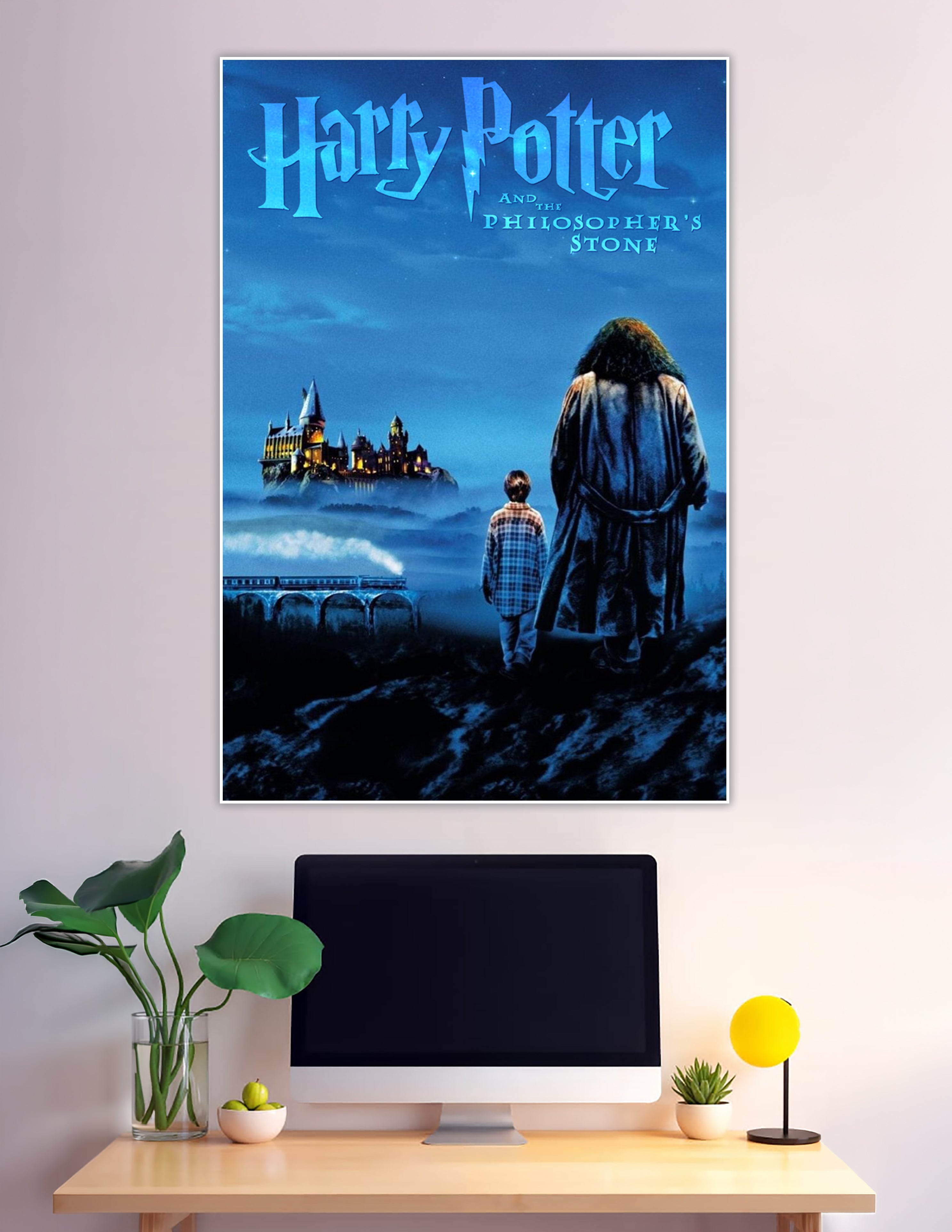 Harry Potter and the Philosopher's Stone movie poster showing two silhouetted figures — a child and a giant — gazing at the glowing Hogwarts castle through misty blue night skies with the Hogwarts Express crossing a viaduct below