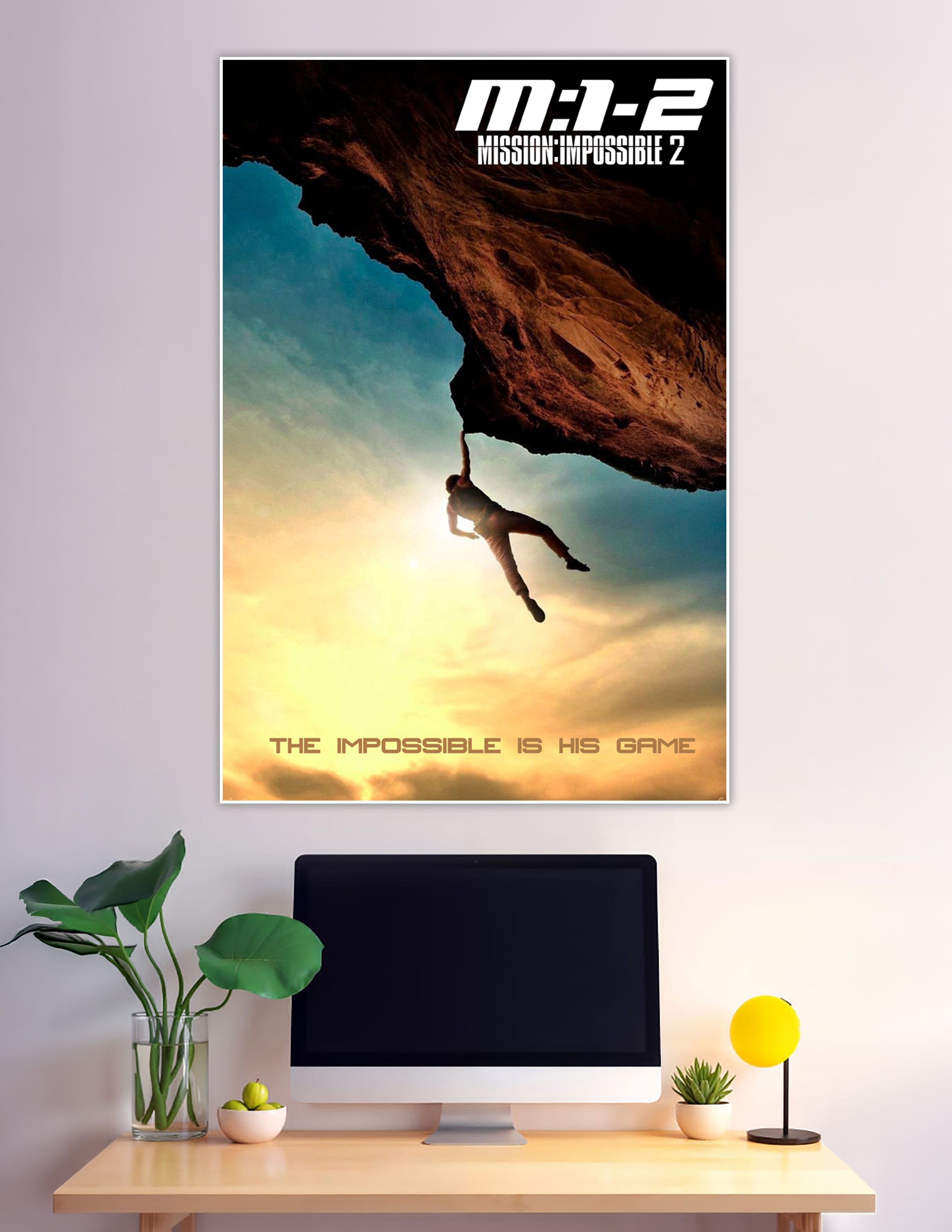 Mission Impossible 2 movie poster showing a silhouetted figure hanging from a rock overhang against a dramatic golden sunset sky with the tagline The Impossible Is His Game