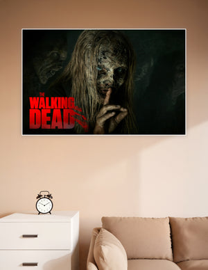 The Walking Dead poster featuring a Whisperer with decayed face and blue eyes making a silence gesture with zombies in the dark background