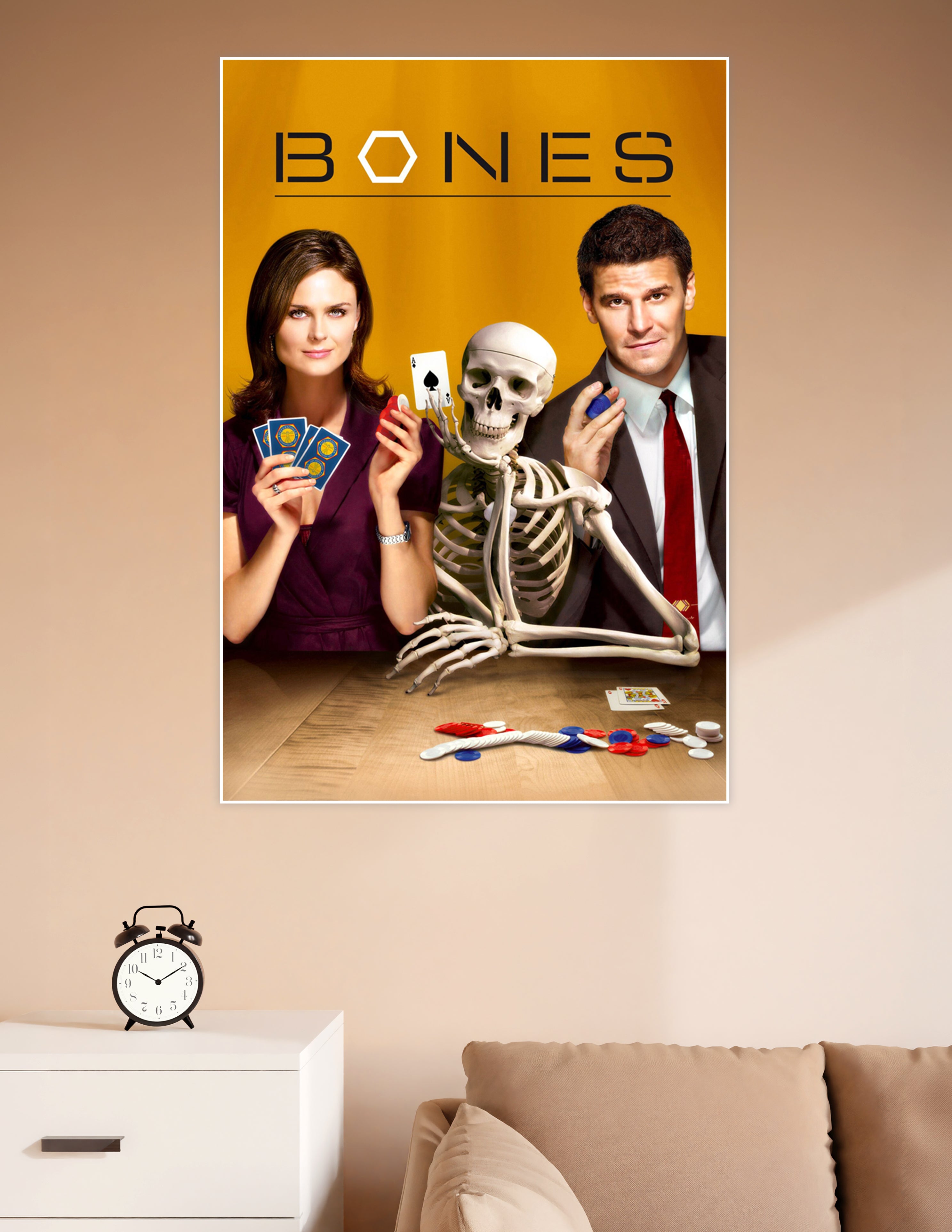 Bones TV show promotional poster featuring two cast members and a skeleton playing poker on a golden background with bold BONES title text