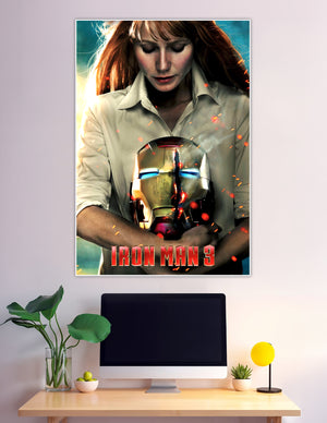 Iron Man 3 movie poster showing a red-haired woman holding a damaged glowing Iron Man helmet with sparks flying around her